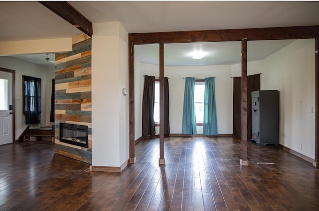 305 2nd Ave SE, Plainview, MN 55964 - unfurnished living room featuring beam ceiling, wood-type flooring, and a glass covered fireplace