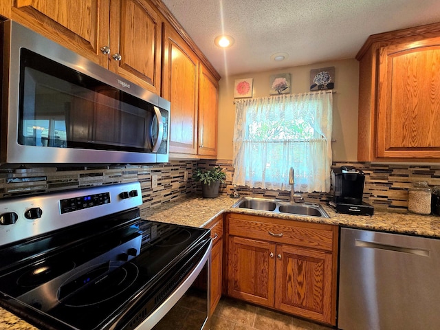 8047 Ingleside Ave S, Cottage Grove, MN 55016 - kitchen with stainless steel appliances, brown cabinets, backsplash, a textured ceiling, and light stone countertops