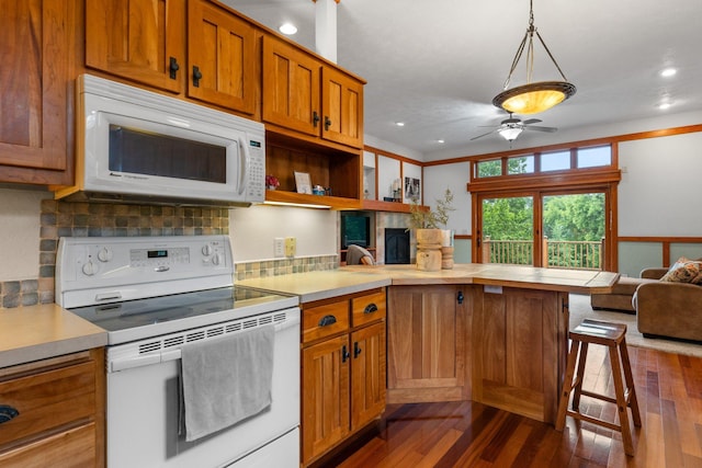 1905 Abby Rd, Cumberland, WI 54829 - kitchen with white appliances, a peninsula, brown cabinetry, dark wood finished floors, and recessed lighting