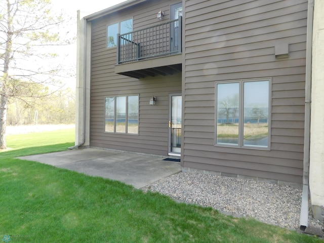42710 County Highway 56 Unit 101, Toad Lake Twp, MN 56544 - rear view of house with a balcony, a patio area, and a lawn