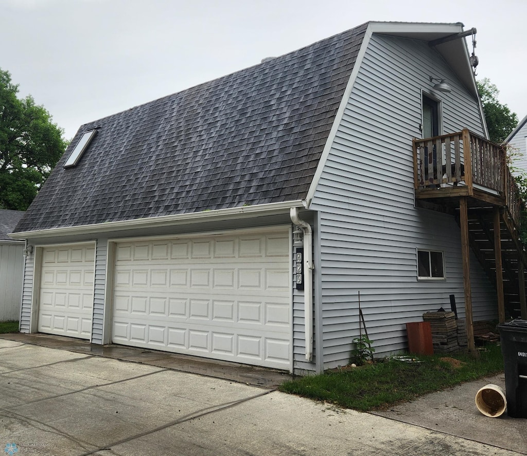 429 9th Ave S, Fargo, ND 58103 - view of side of property featuring a shingled roof, a balcony, and a garage