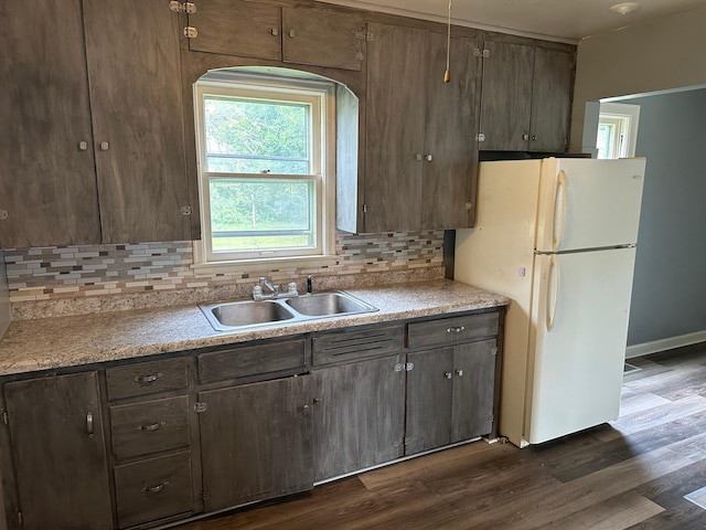 551 Center St, Tracy, MN 56175 - kitchen featuring freestanding refrigerator, decorative backsplash, dark wood-style flooring, and light countertops