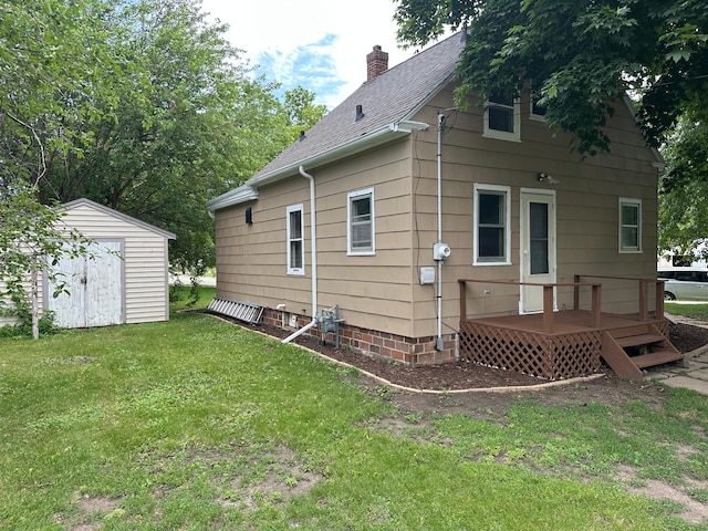 551 Center St, Tracy, MN 56175 - back of property featuring a shed, a yard, a wooden deck, a shingled roof, and a chimney