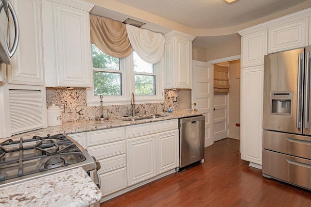 462 Saint Charles St, Winona, MN 55987 - kitchen with appliances with stainless steel finishes, dark wood-style floors, decorative backsplash, and white cabinets