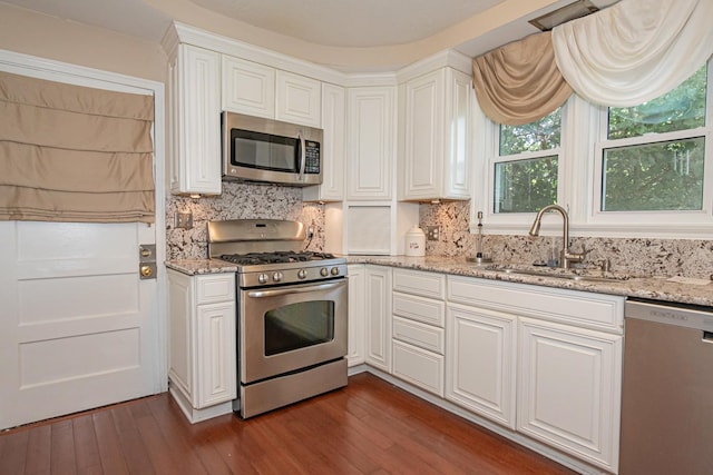 462 Saint Charles St, Winona, MN 55987 - kitchen featuring appliances with stainless steel finishes, dark wood finished floors, white cabinets, tasteful backsplash, and light stone counters