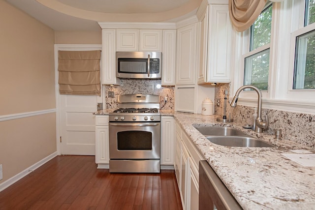 462 Saint Charles St, Winona, MN 55987 - kitchen with stainless steel appliances, decorative backsplash, dark wood-style floors, and white cabinetry