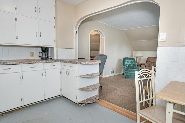 462 Saint Charles St, Winona, MN 55987 - kitchen with arched walkways, white cabinetry, open floor plan, lofted ceiling, and light countertops