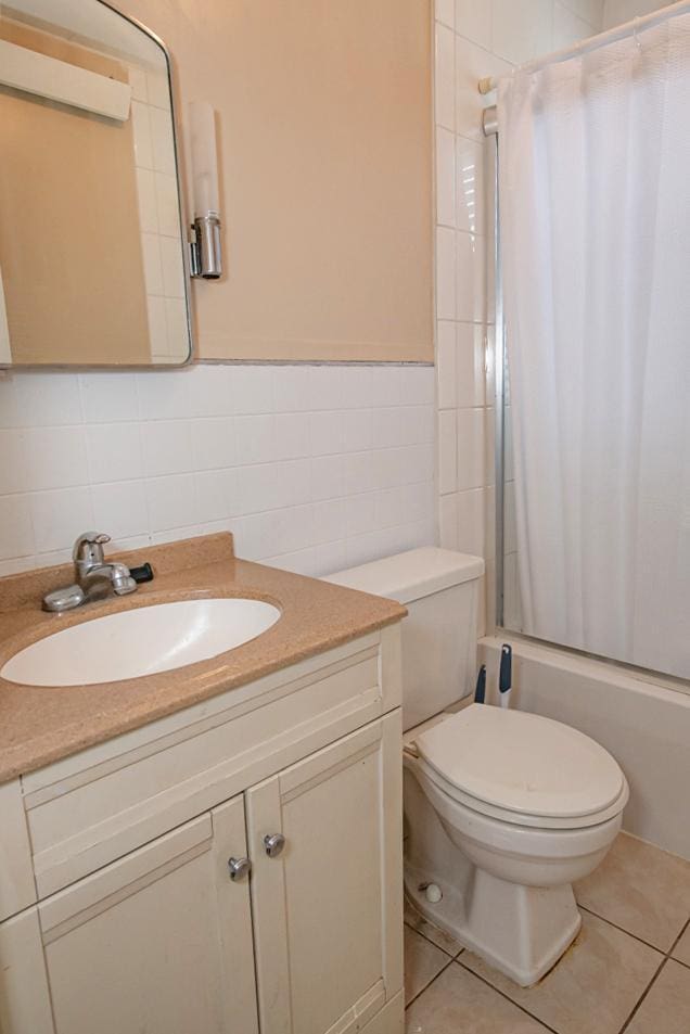 462 Saint Charles St, Winona, MN 55987 - bathroom with tile walls, vanity, shower / bath combo, tile patterned floors, and decorative backsplash