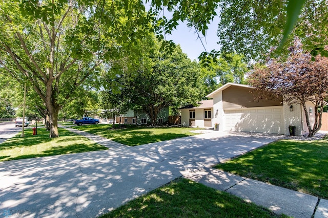 25 Birch Ln S, Fargo, ND 58103 - view of front facade featuring concrete driveway, a front yard, an attached garage, and brick siding