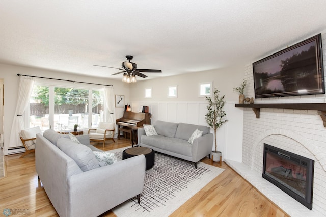 25 Birch Ln S, Fargo, ND 58103 - living area with healthy amount of natural light, ceiling fan, light wood finished floors, a brick fireplace, and wainscoting