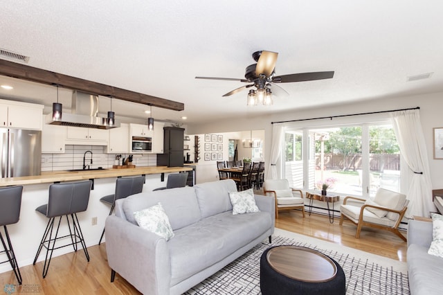 25 Birch Ln S, Fargo, ND 58103 - living room featuring light wood-style floors, a ceiling fan, a baseboard radiator, and recessed lighting
