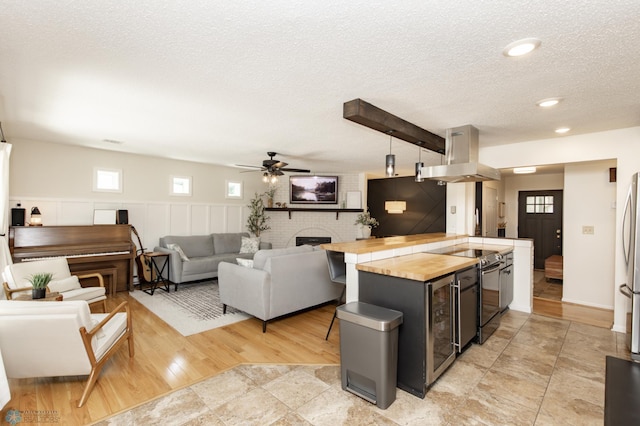 25 Birch Ln S, Fargo, ND 58103 - kitchen featuring island exhaust hood, butcher block countertops, freestanding refrigerator, a textured ceiling, and beverage cooler