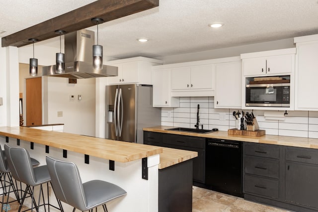 25 Birch Ln S, Fargo, ND 58103 - kitchen with butcher block counters, appliances with stainless steel finishes, wall chimney exhaust hood, white cabinets, and a breakfast bar area