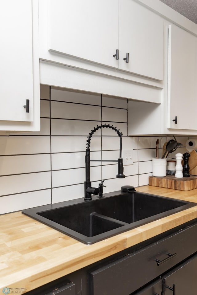 25 Birch Ln S, Fargo, ND 58103 - kitchen featuring butcher block countertops, decorative backsplash, and white cabinetry