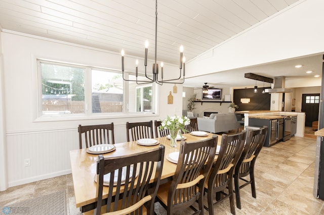25 Birch Ln S, Fargo, ND 58103 - dining room with wooden ceiling, a fireplace, a chandelier, a wainscoted wall, and vaulted ceiling