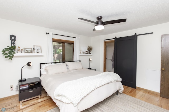 25 Birch Ln S, Fargo, ND 58103 - bedroom with a barn door, wood finished floors, and ceiling fan