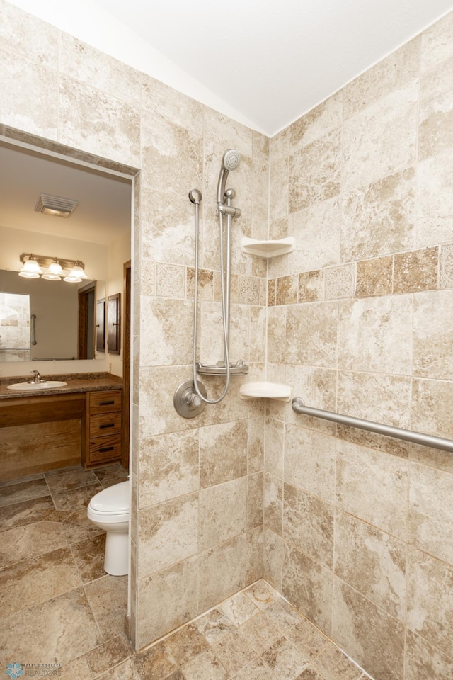 25 Birch Ln S, Fargo, ND 58103 - bathroom featuring tiled shower, vanity, and stone finish floors