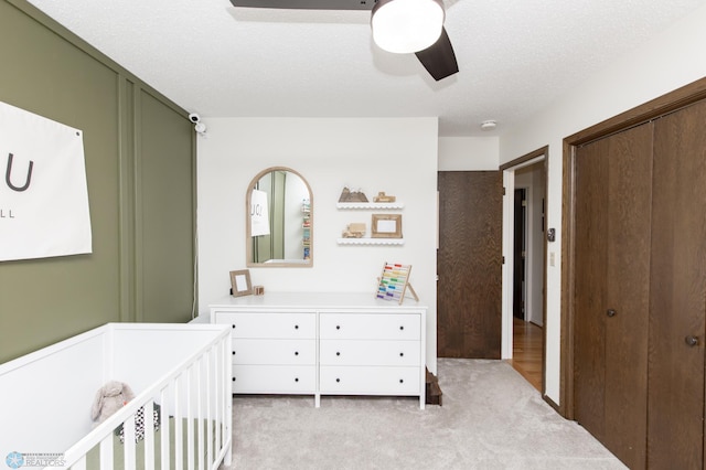 25 Birch Ln S, Fargo, ND 58103 - bedroom with a closet, light colored carpet, a ceiling fan, and a crib