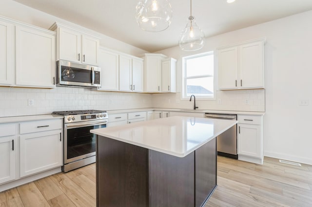 8362 Lander Ave NE, Otsego, MN 55330 - kitchen featuring stainless steel appliances, light countertops, white cabinetry, and light wood-type flooring