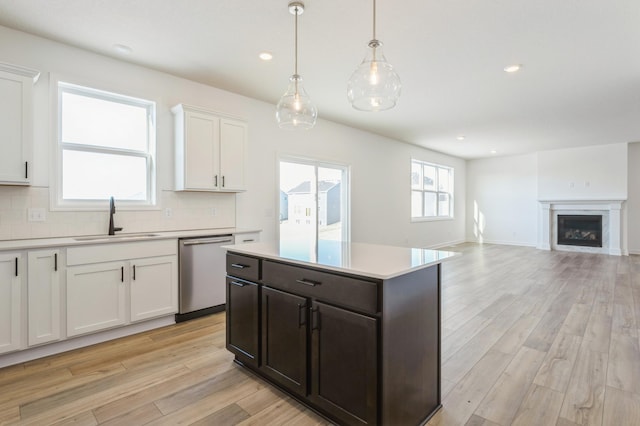 8362 Lander Ave NE, Otsego, MN 55330 - kitchen featuring stainless steel dishwasher, light countertops, white cabinetry, light wood-type flooring, and tasteful backsplash