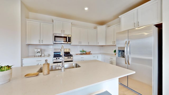 7593 Norway Ln, Lino Lakes, MN 55038 - kitchen with appliances with stainless steel finishes, backsplash, white cabinets, recessed lighting, and light stone countertops