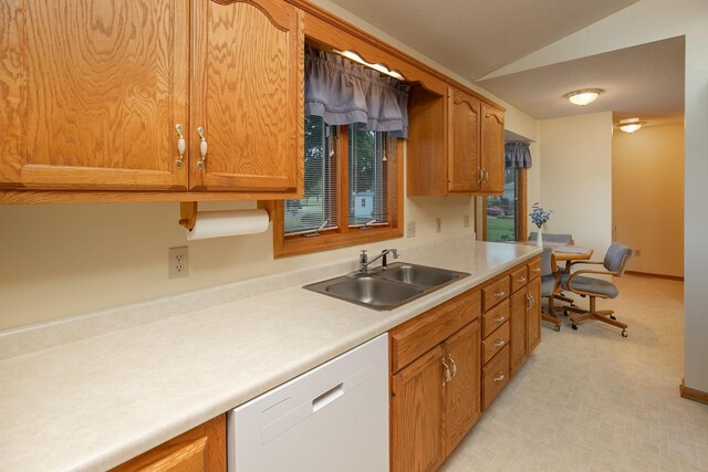 104 County Rd N, Le Roy, MN 55951 - kitchen with dishwasher, vaulted ceiling, light countertops, brown cabinetry, and light carpet
