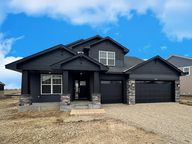6722 Tamarack Ln, Corcoran, MN 55340 - craftsman house featuring driveway, stone siding, and a garage