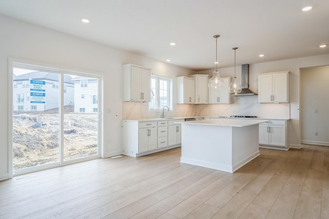 6722 Tamarack Ln, Corcoran, MN 55340 - kitchen featuring wall chimney range hood, light wood finished floors, light countertops, white cabinets, and recessed lighting