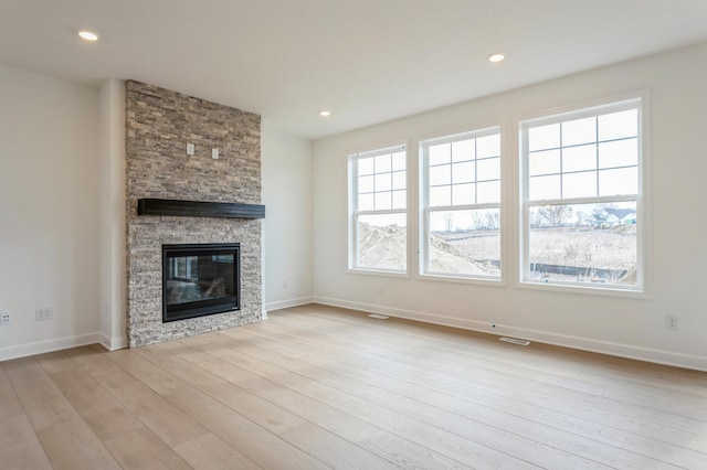 6722 Tamarack Ln, Corcoran, MN 55340 - unfurnished living room with wood finished floors, a stone fireplace, and recessed lighting