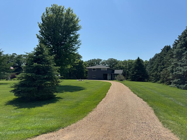 715 250th Ave, Fairmont, MN 56031 - view of front of home with dirt driveway, a front yard, and a wooded view