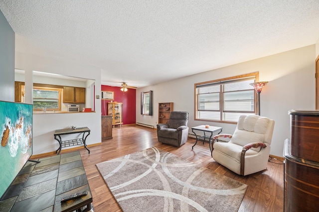 2227 3rd St SW, Rochester, MN 55902 - living room featuring light wood-style floors, a textured ceiling, a ceiling fan, and a baseboard heating unit