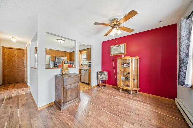 2227 3rd St SW, Rochester, MN 55902 - kitchen featuring stainless steel appliances, baseboard heating, a wall unit AC, brown cabinets, and a ceiling fan