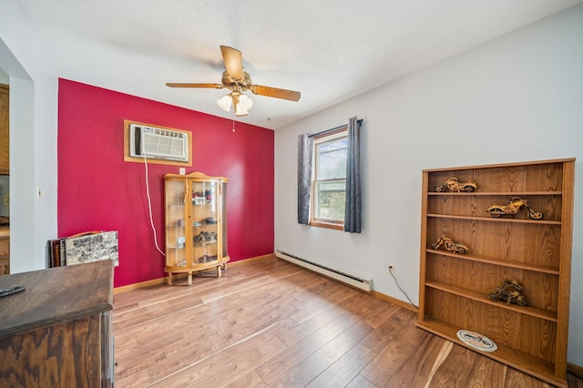 2227 3rd St SW, Rochester, MN 55902 - misc room with a baseboard heating unit, a ceiling fan, hardwood / wood-style floors, and a wall mounted air conditioner