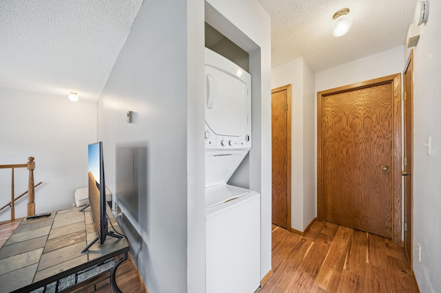 2227 3rd St SW, Rochester, MN 55902 - washroom featuring stacked washer / dryer, a textured ceiling, and wood finished floors