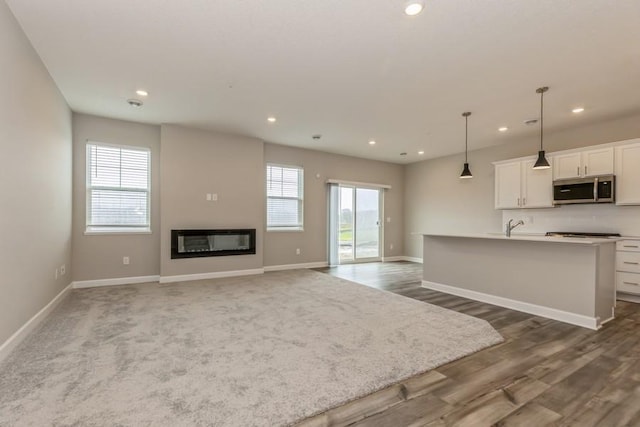 20025 62nd Pl, Corcoran, MN 55340 - unfurnished living room with recessed lighting, dark wood-type flooring, and a glass covered fireplace
