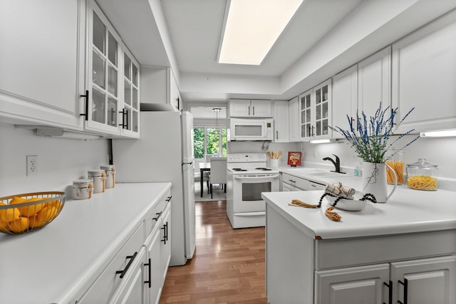 3412 Oak Ridge Rd Unit 208, Minnetonka, MN 55305 - kitchen with white appliances, wood finished floors, light countertops, and glass insert cabinets