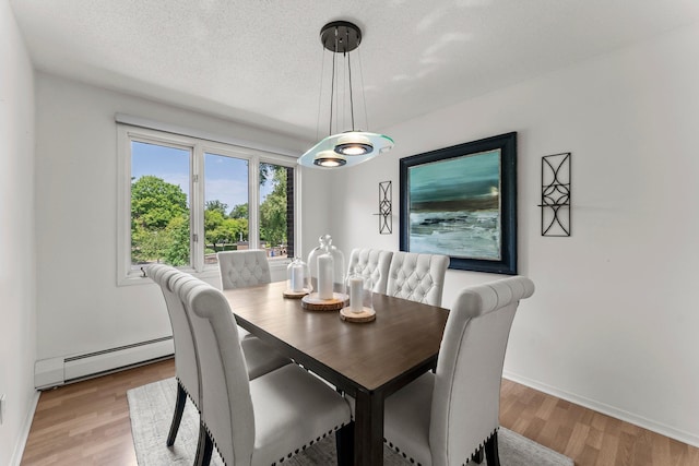 3412 Oak Ridge Rd Unit 208, Minnetonka, MN 55305 - dining space featuring a baseboard heating unit, light wood-style flooring, and a textured ceiling