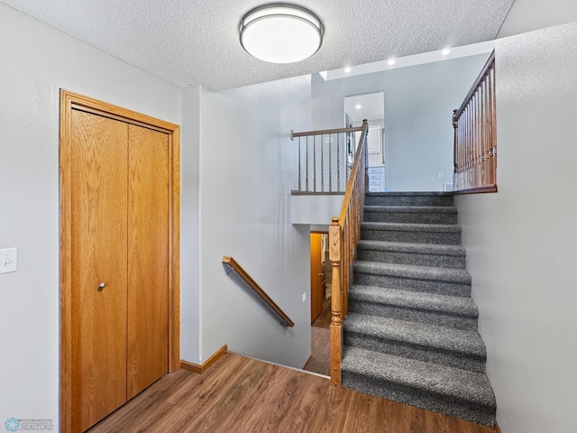 3337 Monroe St S, Fargo, ND 58104 - staircase with a textured ceiling and wood finished floors