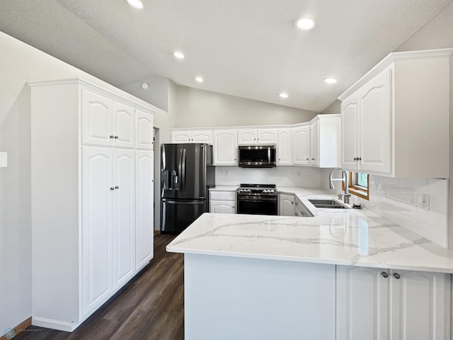 3337 Monroe St S, Fargo, ND 58104 - kitchen with stainless steel appliances, a peninsula, dark wood-type flooring, vaulted ceiling, and light stone countertops