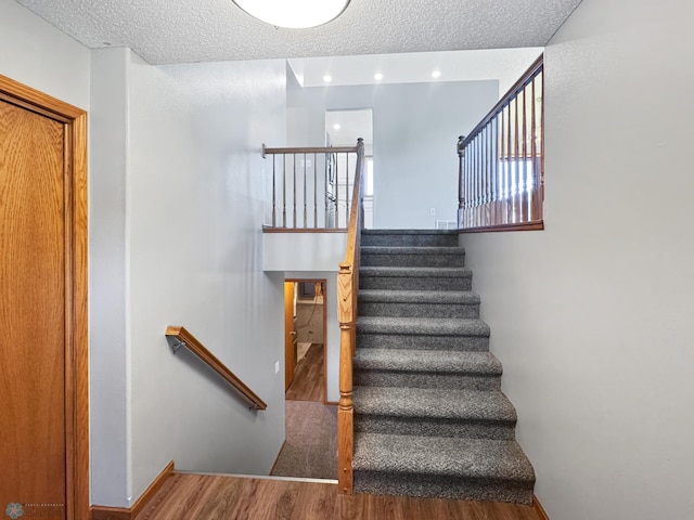 3337 Monroe St S, Fargo, ND 58104 - stairway featuring wood finished floors and a textured ceiling
