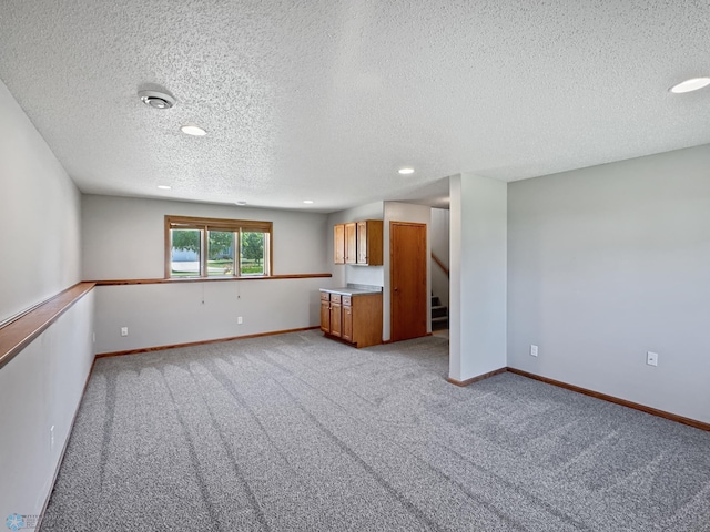 3337 Monroe St S, Fargo, ND 58104 - unfurnished living room featuring a textured ceiling, recessed lighting, light carpet, and stairway