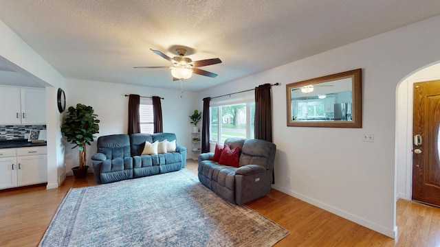 711 5th Ave SW, Austin, MN 55912 - living area with arched walkways, ceiling fan, light wood-type flooring, and a textured ceiling