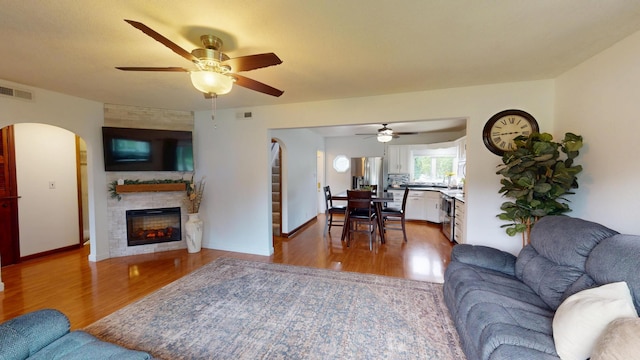 711 5th Ave SW, Austin, MN 55912 - living area with ceiling fan, wood finished floors, arched walkways, and a glass covered fireplace