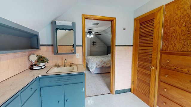 711 5th Ave SW, Austin, MN 55912 - bathroom with lofted ceiling, vanity, a ceiling fan, ensuite bathroom, and tile walls