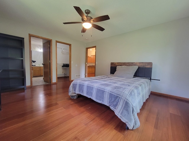 2729 Parkhaven Ct N, Brooklyn Park, MN 55444 - bedroom featuring wood finished floors, a spacious closet, a closet, ceiling fan, and ensuite bath