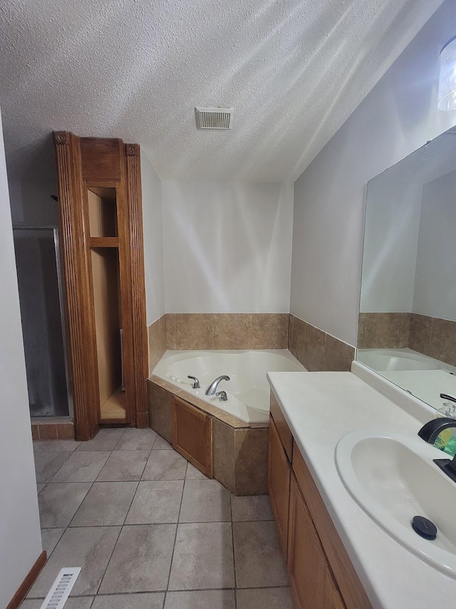 2729 Parkhaven Ct N, Brooklyn Park, MN 55444 - bathroom featuring a bath, vanity, a textured ceiling, and tile patterned flooring