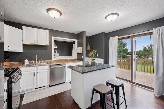 420 Pleasant Crest Cir, Annandale, MN 55302 - kitchen with stainless steel dishwasher, gas range oven, white cabinetry, a textured ceiling, and dark wood-style floors