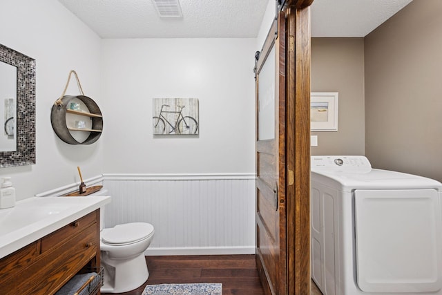 420 Pleasant Crest Cir, Annandale, MN 55302 - bathroom featuring washer / clothes dryer, wood finished floors, a wainscoted wall, vanity, and a textured ceiling