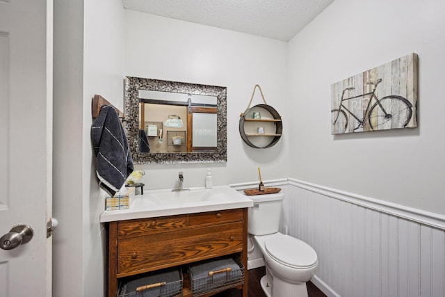 420 Pleasant Crest Cir, Annandale, MN 55302 - bathroom with wainscoting, vanity, and a textured ceiling