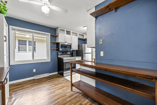 2717 22nd St, Minneapolis, MN 55406 - kitchen with appliances with stainless steel finishes, open shelves, light wood-type flooring, white cabinetry, and ceiling fan
